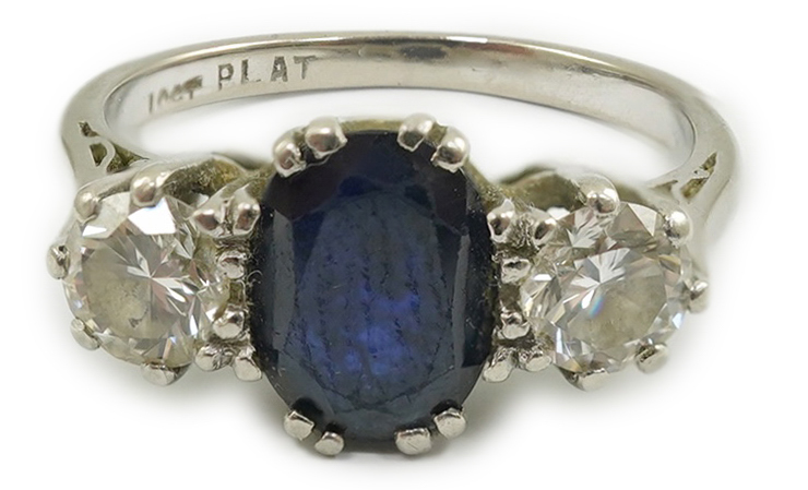 An 18ct white gold and platinum, single stone oval cut sapphire and two stone round cut diamond set ring